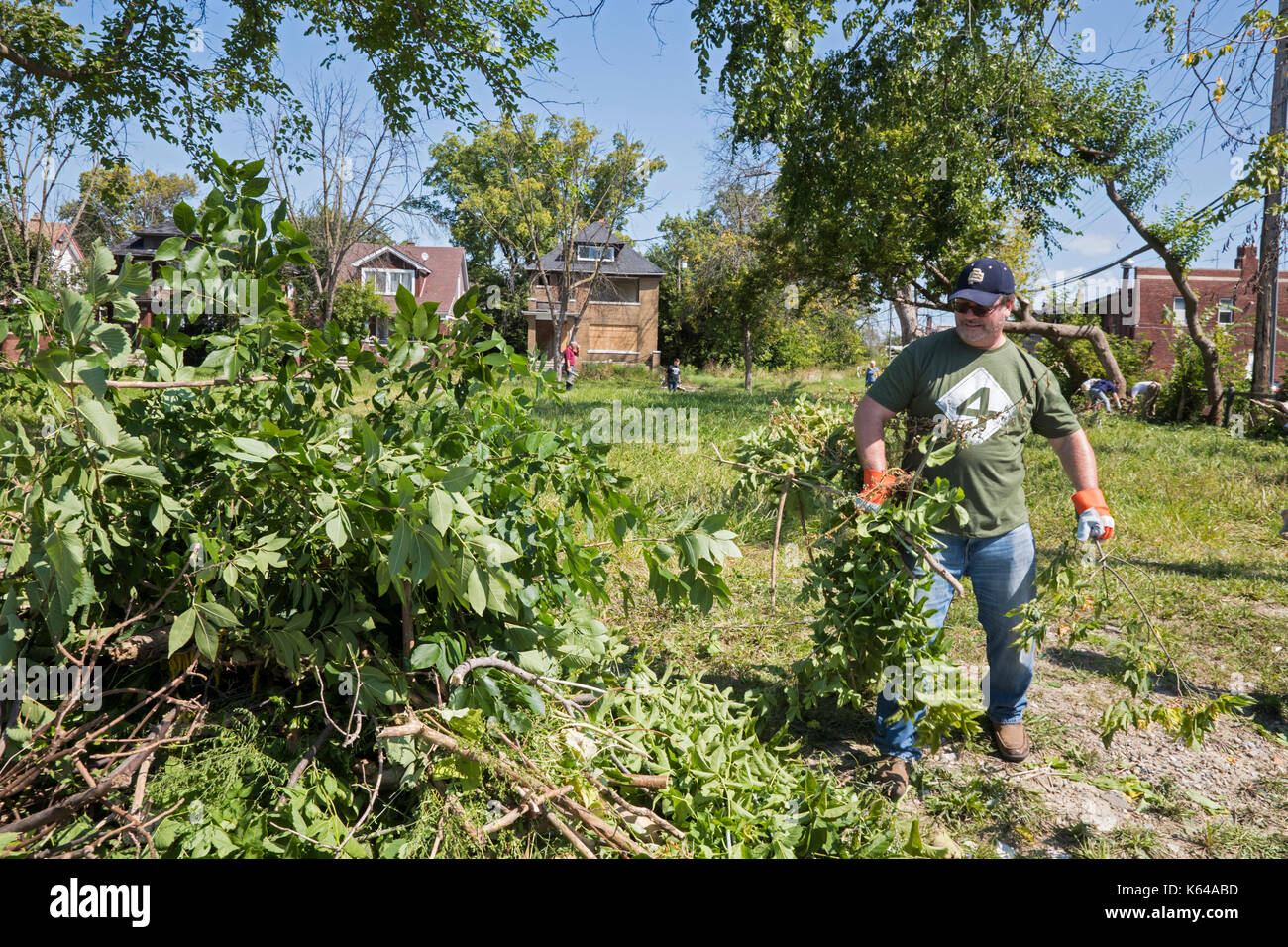Detroit, Michigan - Community residents and members of the Knights of Columbus clean trash and brush from vacant lots in the Morningside neighborhood. Stock Photo