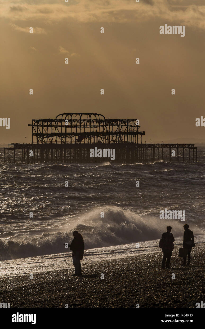 Brighton, UK. 11th Sep, 2017. UK Weather. The sunset breaks through the clouds over the remains of the old pier - Dusk on a blustery evening on Brighton Beach. Credit: Guy Bell/Alamy Live News Stock Photo