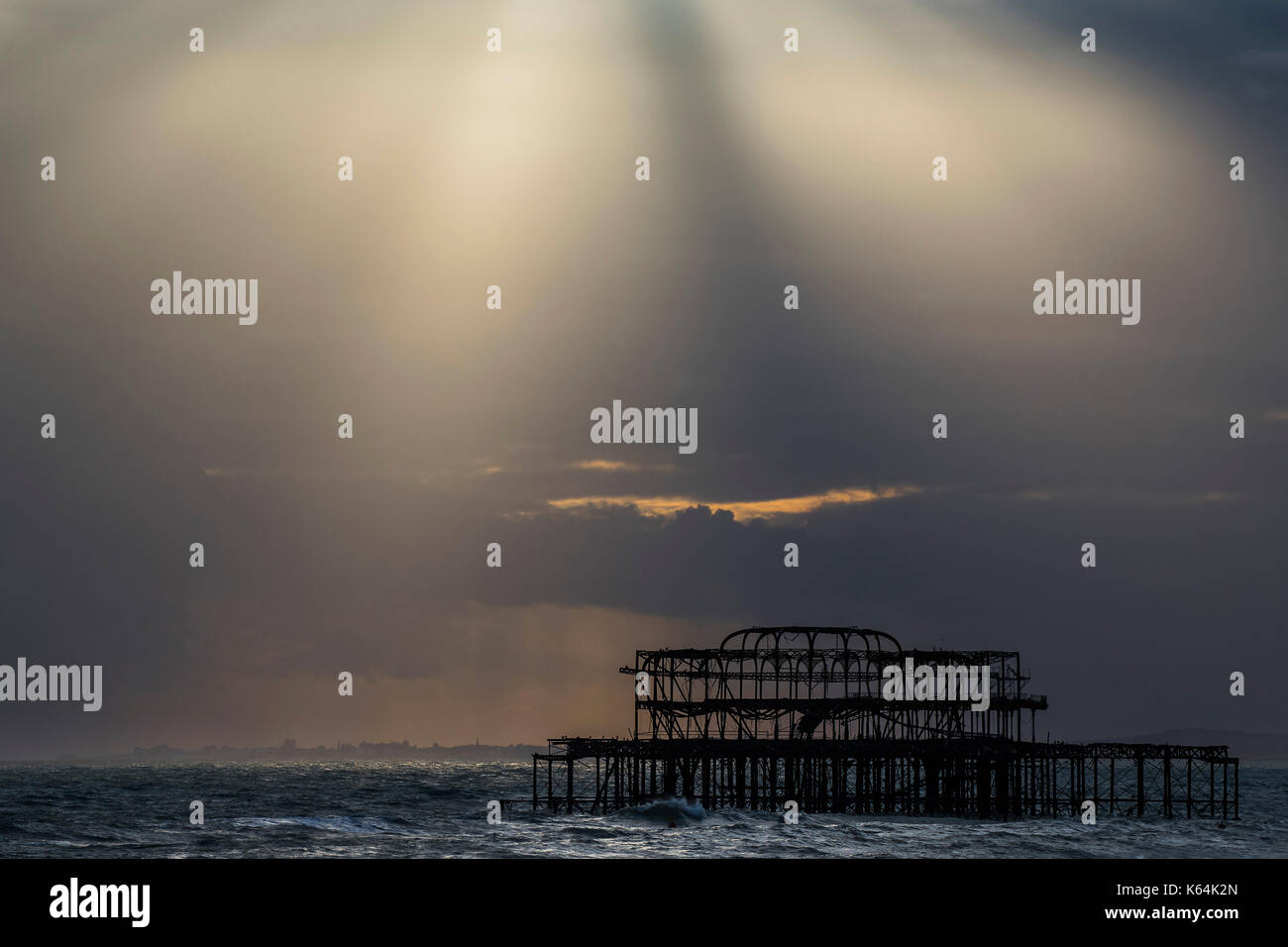 Brighton, UK. 11th Sep, 2017. UK Weather. The sunset breaks through the clouds over the remains of the old pier - Dusk on a blustery evening on Brighton Beach. Credit: Guy Bell/Alamy Live News Stock Photo
