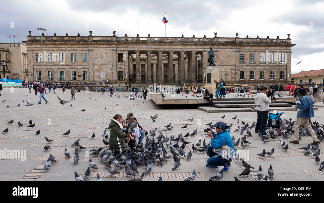 Colombia: Bogota.  Family posing in the middle of pigeons in front of the National Capitol, headquarters of the Colombian Congress in Bolivar Square. Stock Photo