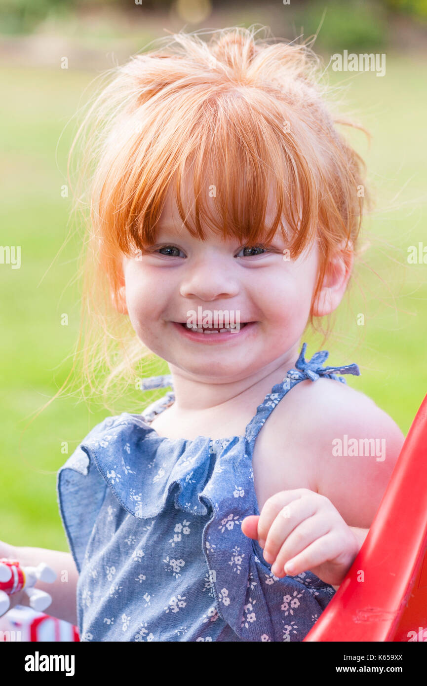 A MODEL RELEASED 2 year old girl with ginger hair outdoors in the Uk Stock Photo