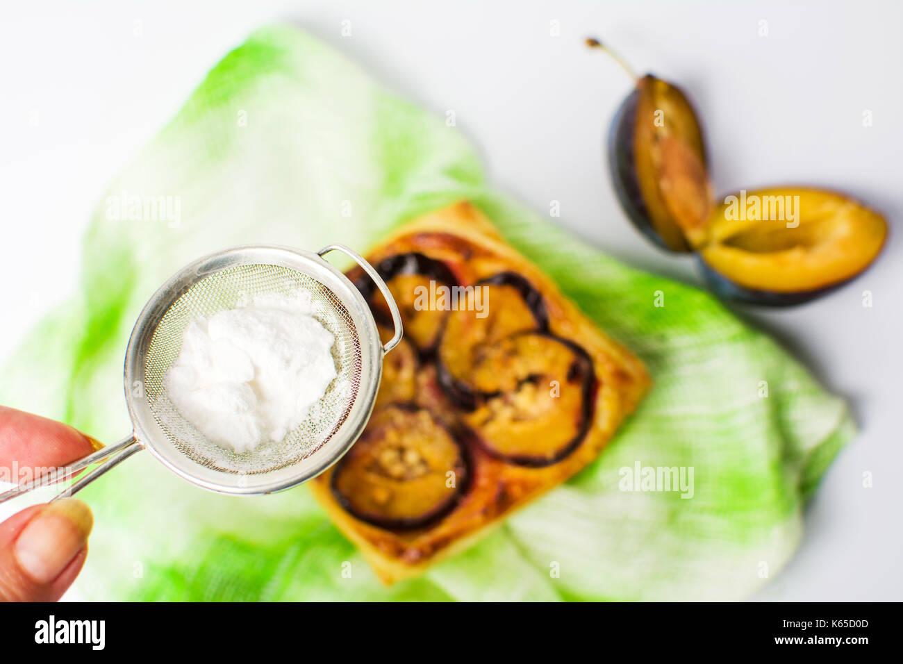 Adding sugar to plum sweet pie slice Stock Photo