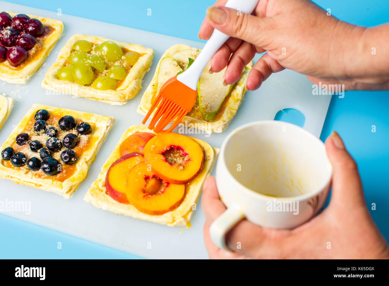 Chef applying egg on the fruit sweet pie before baking Stock Photo