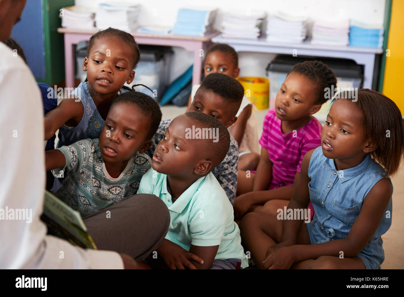 Teacher reading book to elementary school children in class Stock Photo