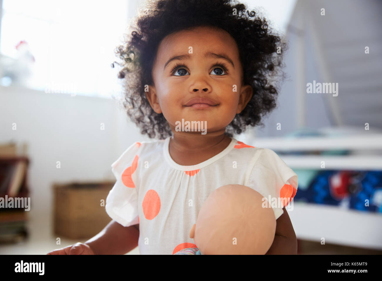 Happy Baby Girl Playing With Doll In Playroom Stock Photo