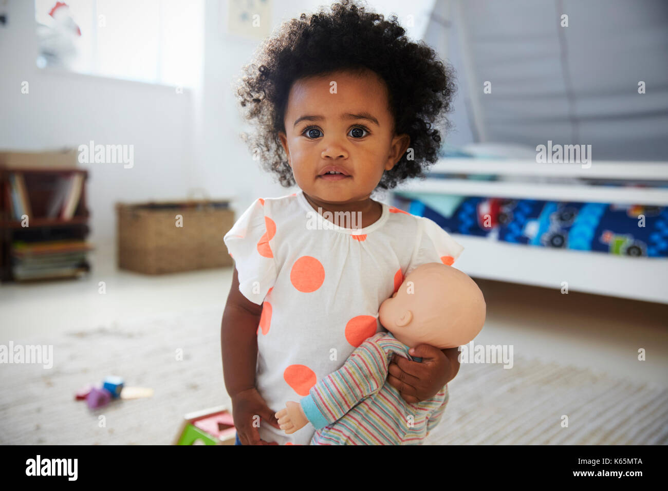 Portrait Of Baby Girl Playing With Doll In Playroom Stock Photo - Alamy