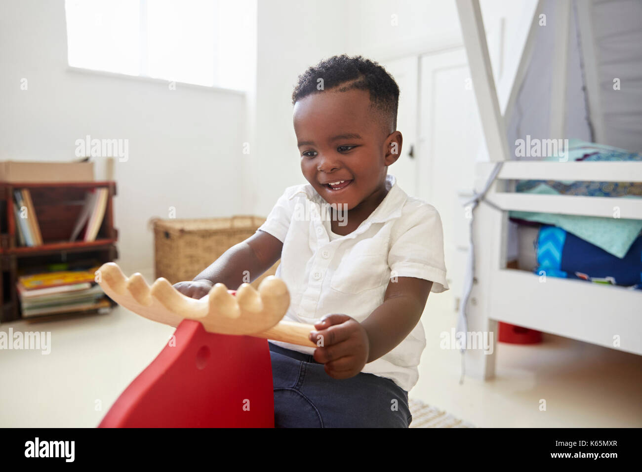 Young Boy Sitting On Ride On Toy In Playroom Stock Photo - Alamy