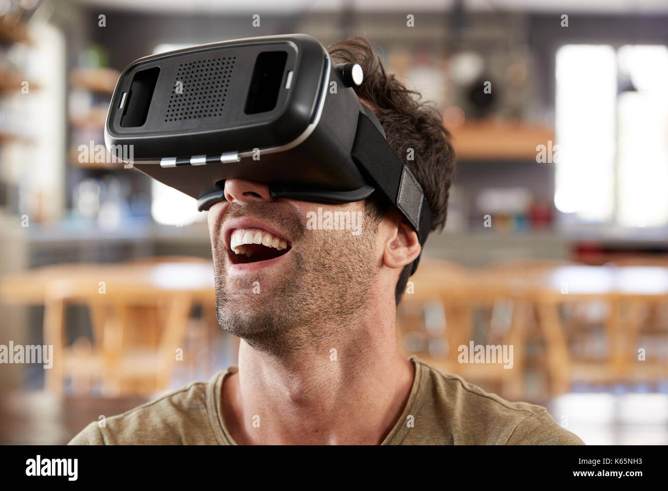 Man Sitting On Sofa Wearing Virtual Reality Headset Stock Photo