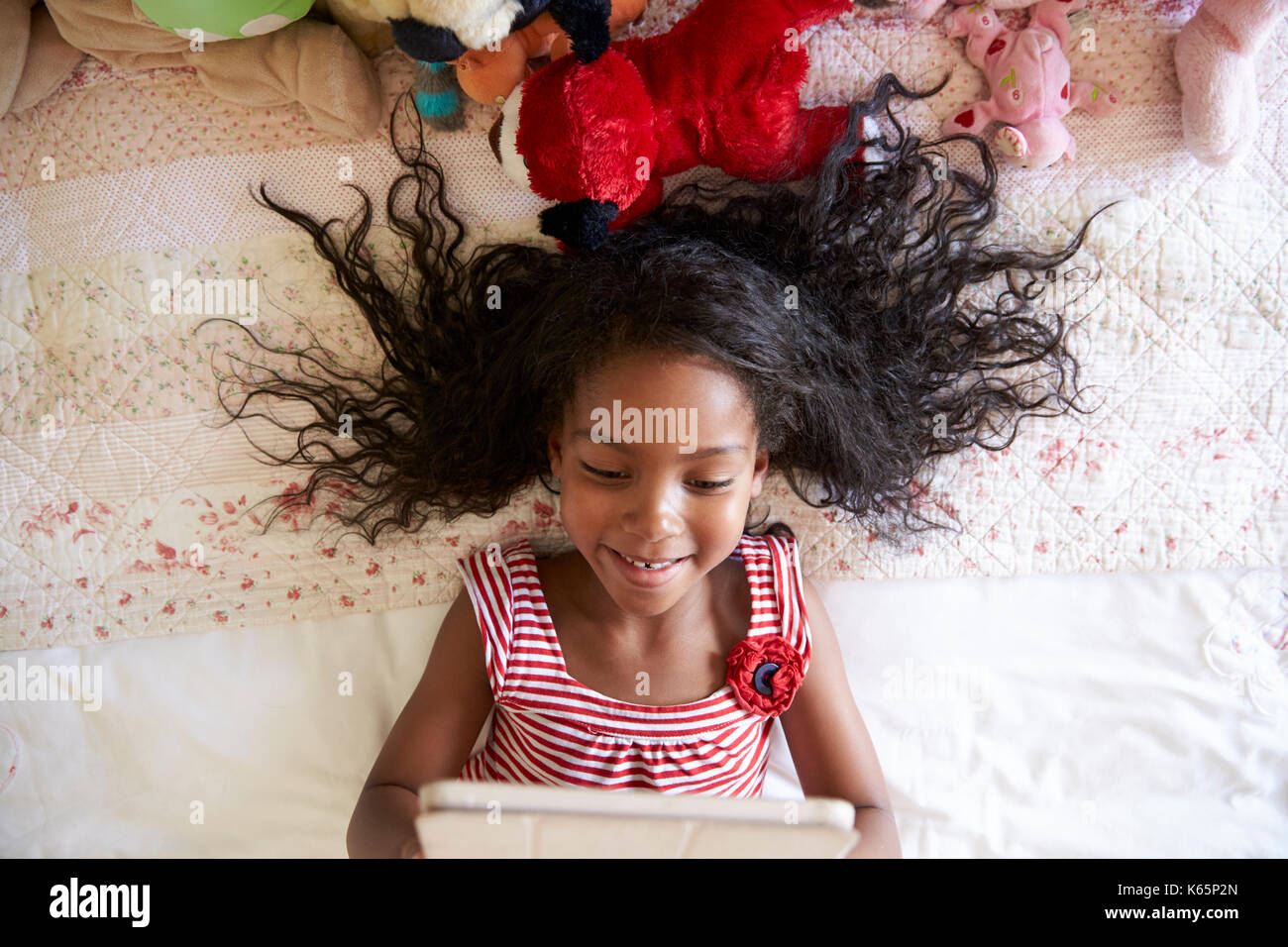 Young Girl Lying On Bed Using Digital Tablet Stock Photo - Alamy