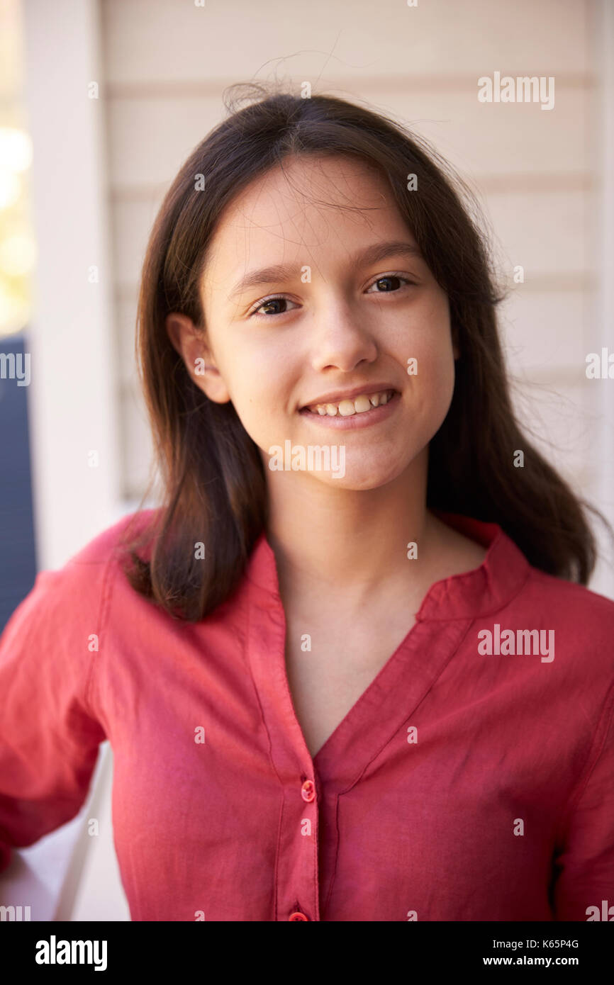 Head And Shoulders Portrait Of Girl Outside House Stock Photo