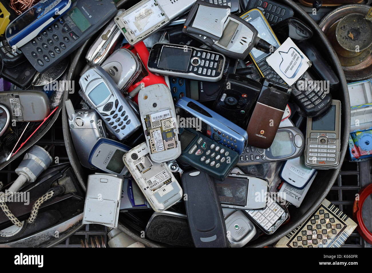 ATHENS, GREECE - AUGUST 4, 2016: Old mobile cell phones. Pile of broken handphones for sale at junk shop. Stock Photo