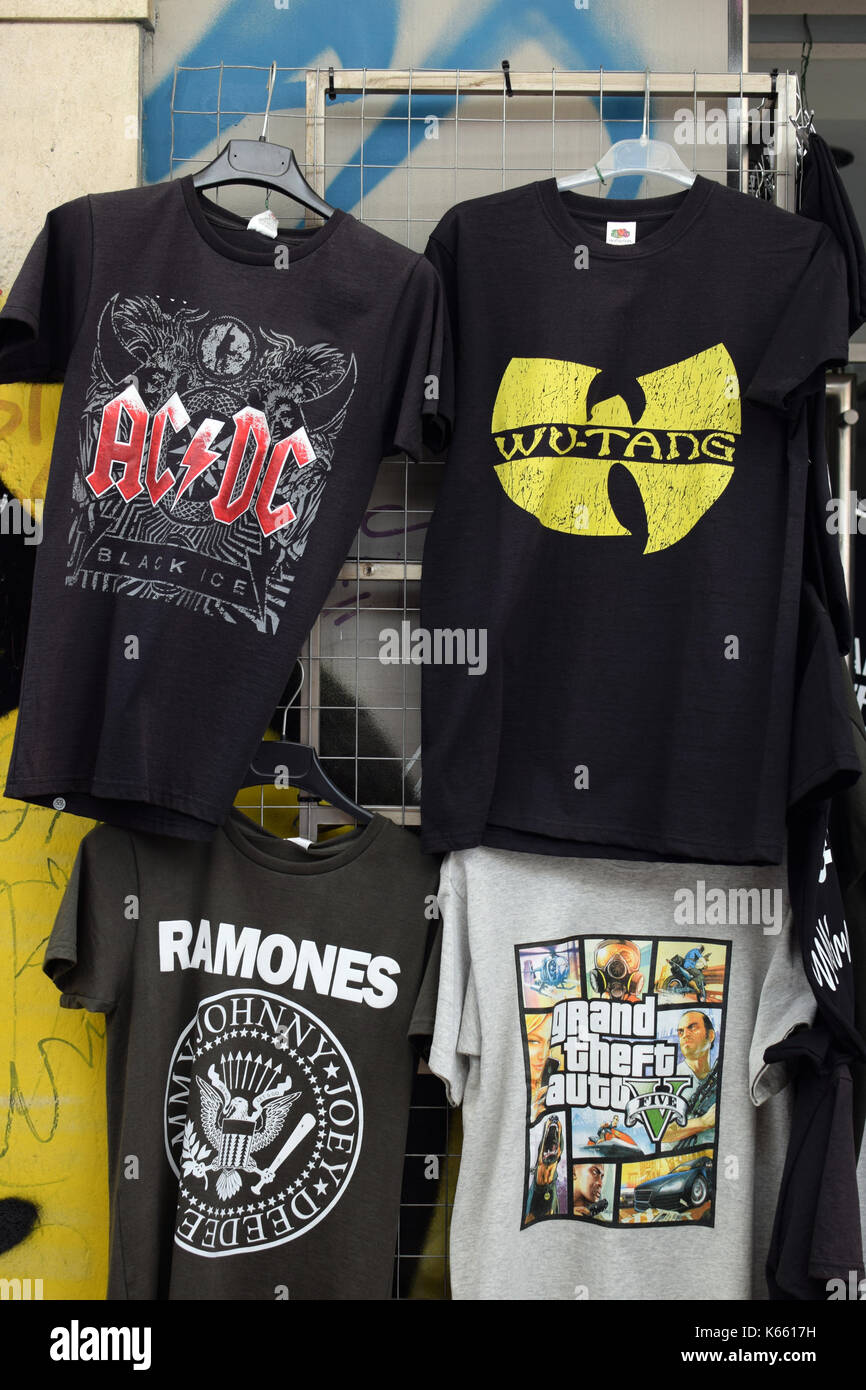 ATHENS, GREECE - AUGUST 4, 2016: Rock and hip hop music t-shirts for sale printed with band logos by The Ramones, AC/DC and Wu-Tang Clan. Stock Photo