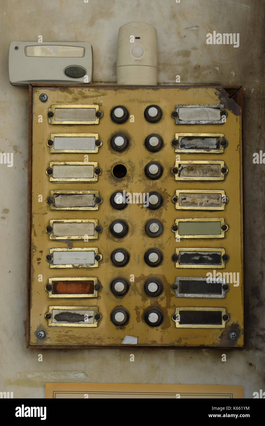 Old weathered doorbell panel in apartment building. Grungy door bell buzzer with broken buttons. Stock Photo