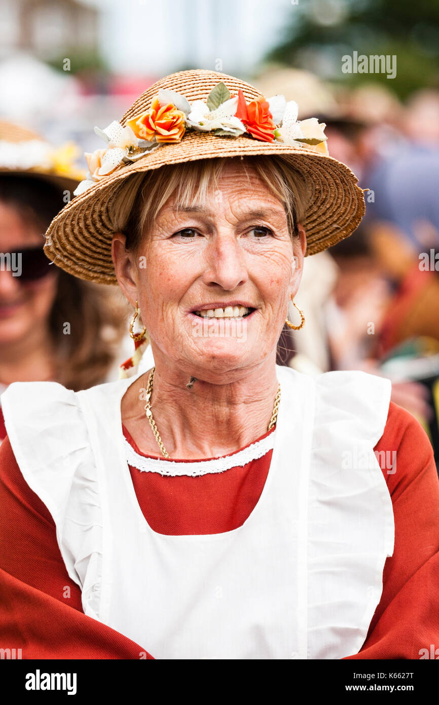 England, Broadstairs folk week. Middle aged woman from the Rising Lark Morris side. Facing, close up of head and shoulders, smiling, wears straw hat. Stock Photo