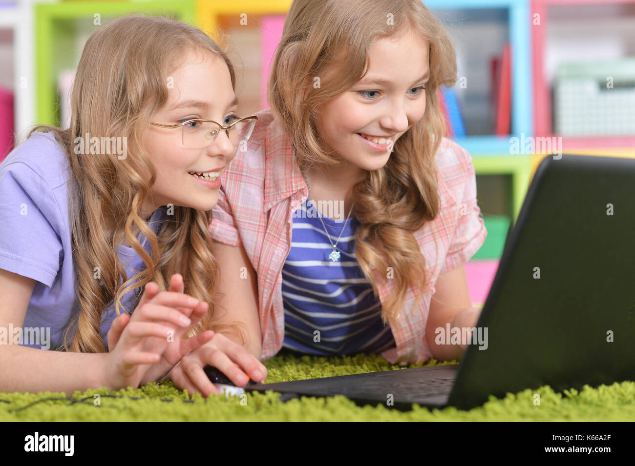 Teenagers sisters using laptop Stock Photo - Alamy