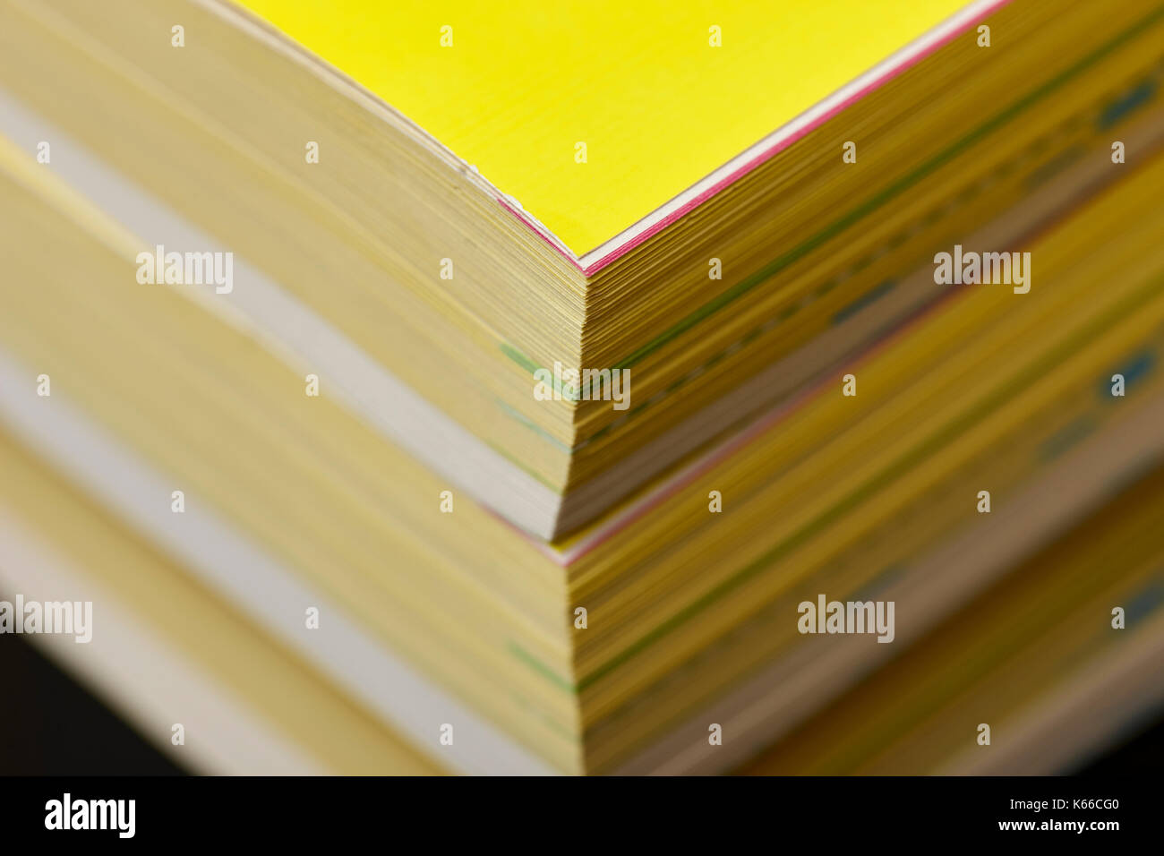 thickness of old versions of yellow pages classified telephone directory paper edition uk Stock Photo