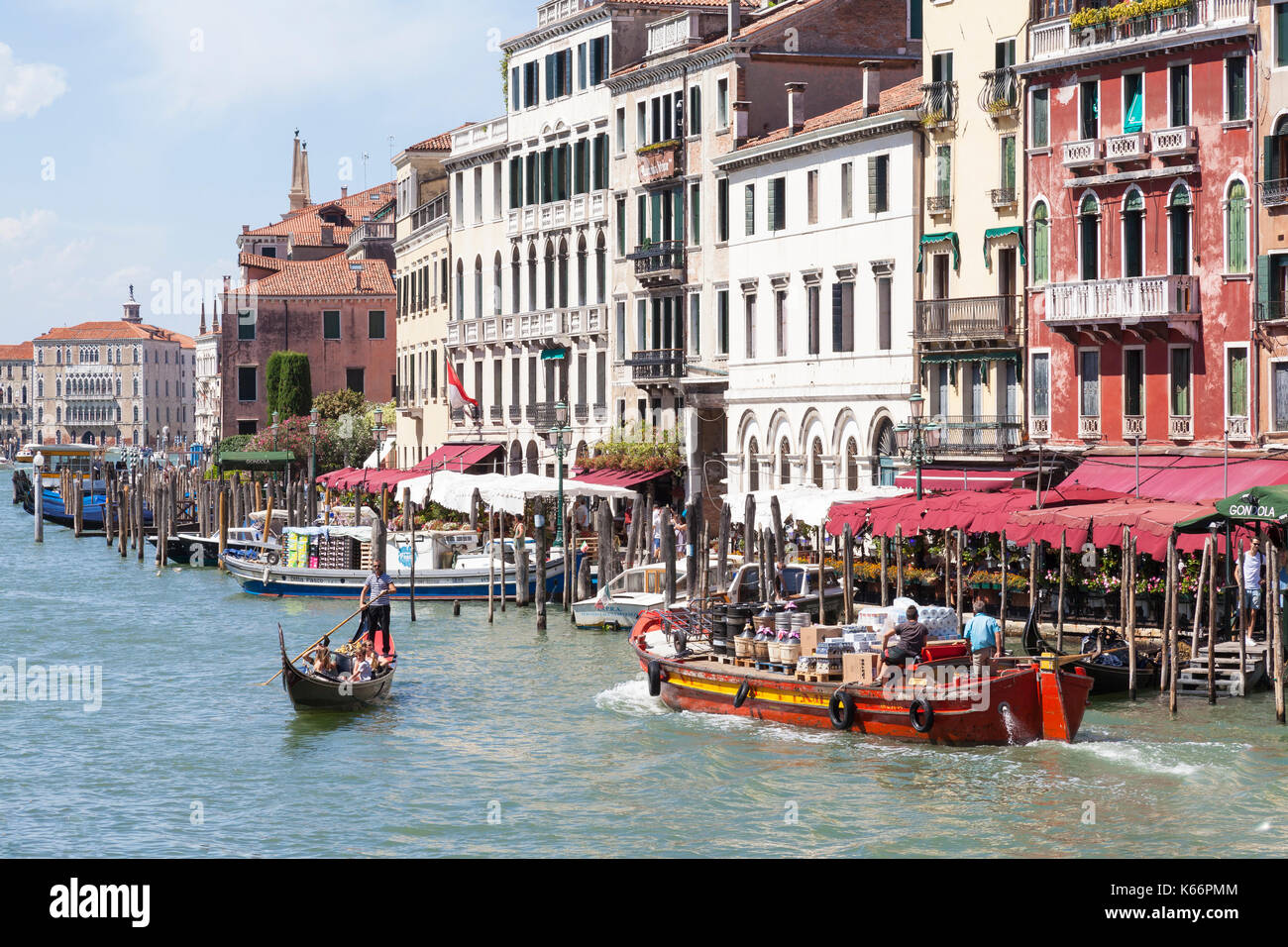 Colorful red boat transporting large bottles of wine, Grand Canal