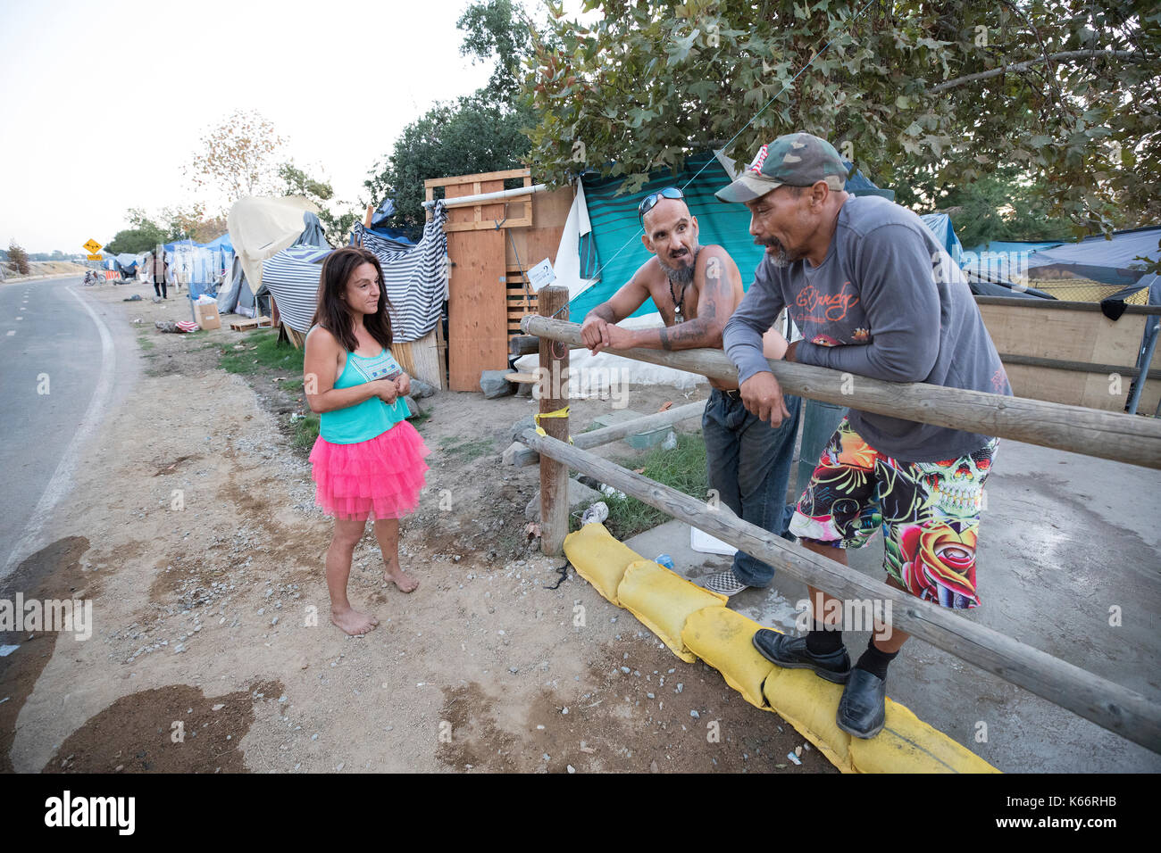 (L-R) Michelle, Bo Bo and Rudy chat at at the Santa Ana River bike trail homeless encampment Stock Photo