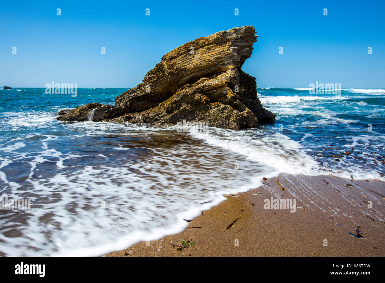 Waves splashing on rock at ocean beach Stock Photo