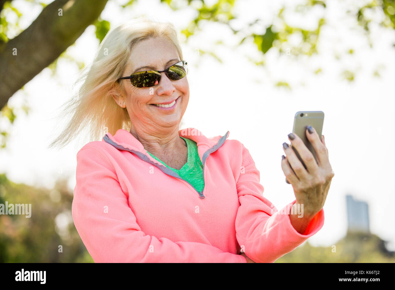 Wind blowing hair of Caucasian woman texting on cell phone Stock Photo