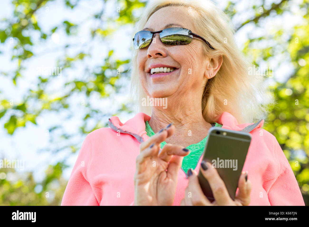 Older Caucasian woman texting on cell phone outdoors Stock Photo