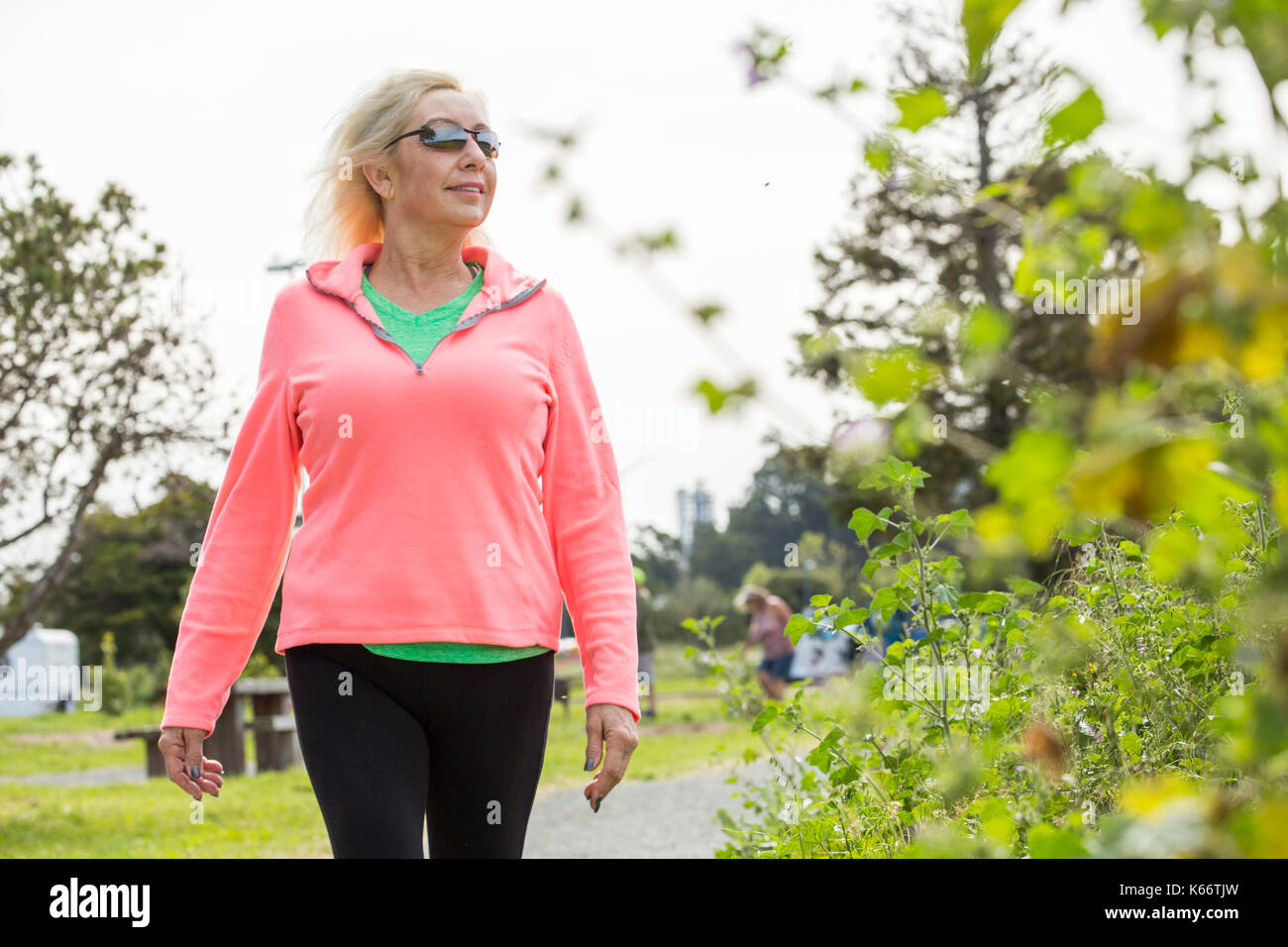 Older Caucasian woman walking in park Stock Photo