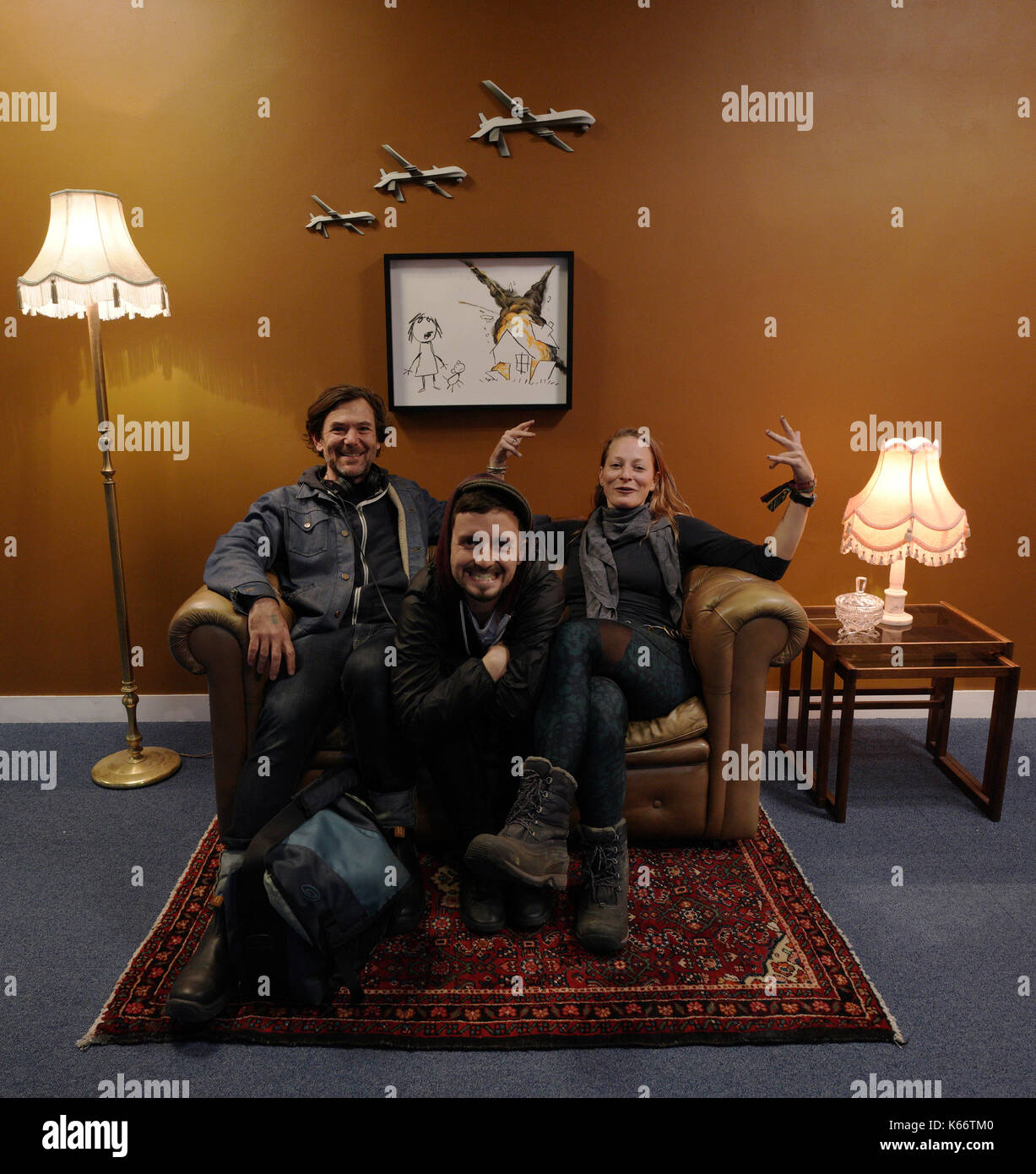 STANDALONE PHOTO Visitors sat on an installation by artist Banksy, entitled Civilian  Drone Strike, on display at the Art the Arms Fair art exhibition - which  has been set up in opposition
