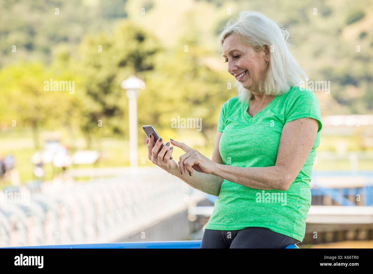 Older Caucasian woman texting on cell phone outdoors Stock Photo