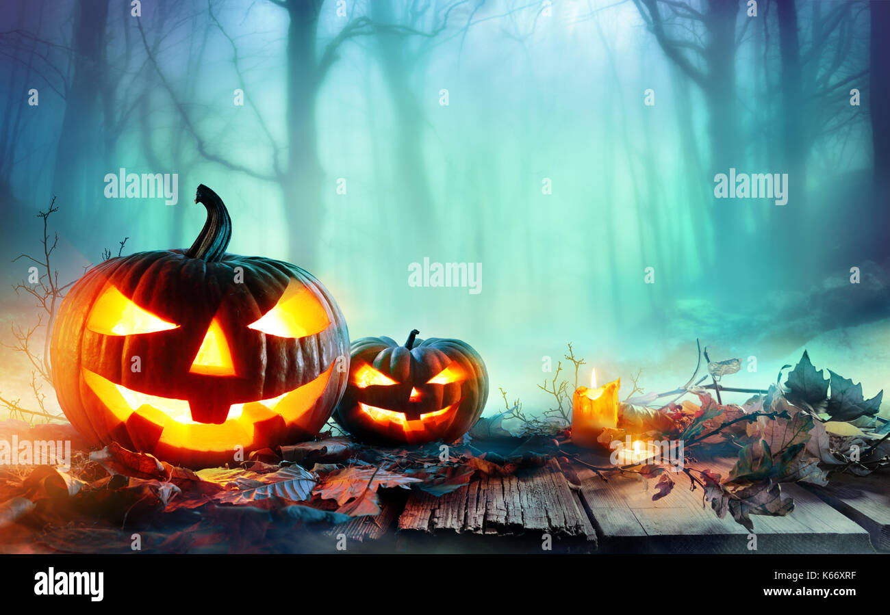 Pumpkins Burning In A Spooky Forest At Night - Halloween Background Stock Photo