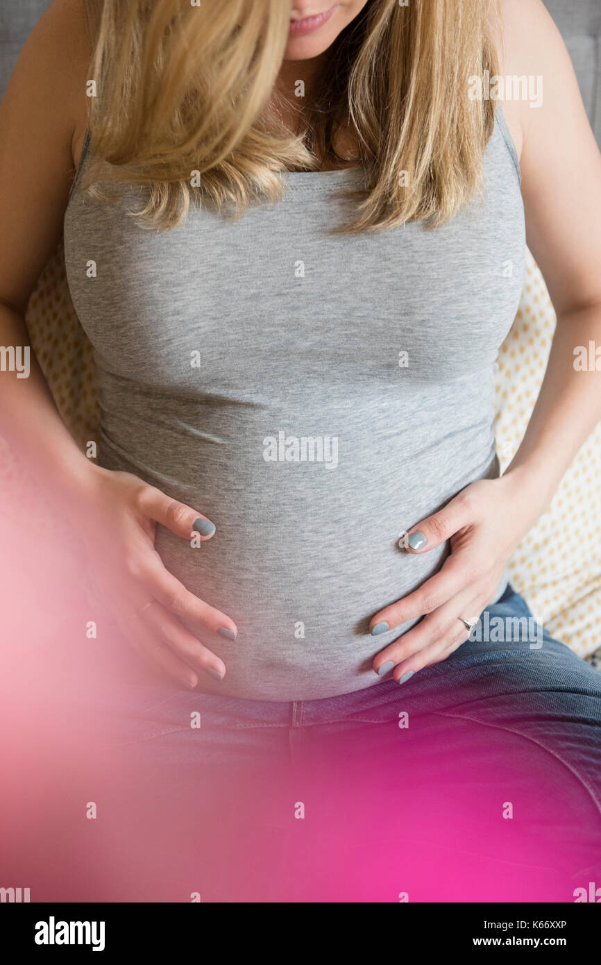 Caucasian expectant mother holding belly Stock Photo - Alamy