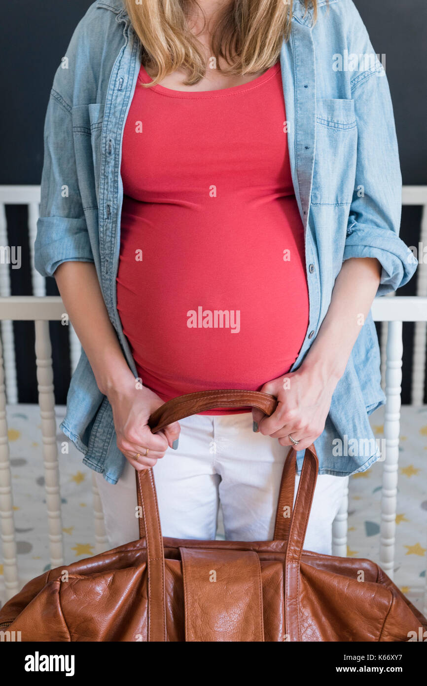 Caucasian expectant mother carrying bag Stock Photo Alamy