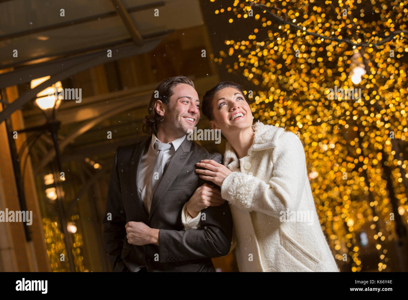 Caucasian couple walking in city at night Stock Photo