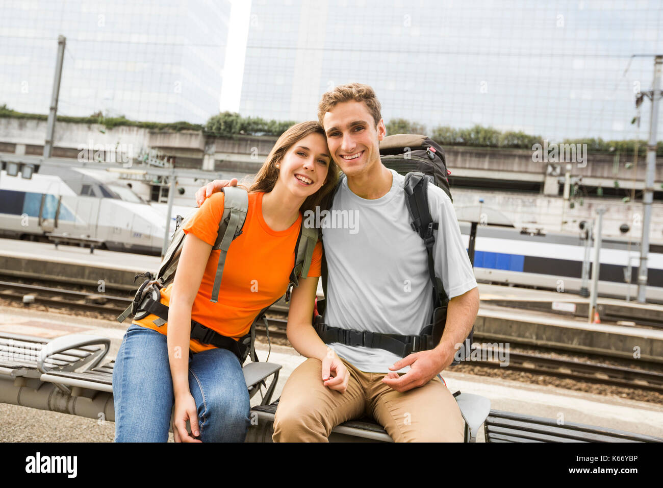 Caucasian couple waiting on bench at train station Stock Photo