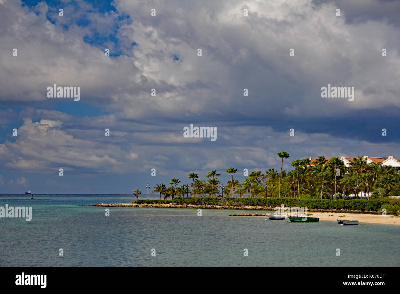 Beautiful view of the bay in Aruba.  Boats along the shore, palm trees and sunny blue skies. Stock Photo