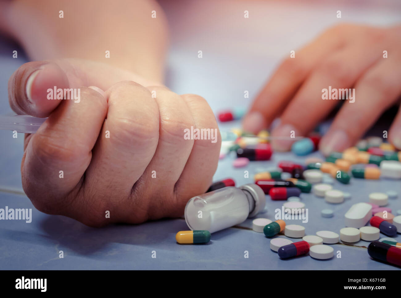 Overdose - close up of pills and addict lying on the floor Stock Photo