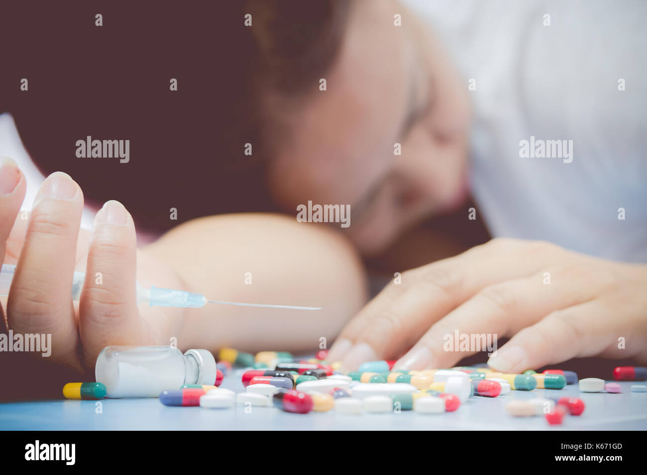 Overdose - close up of pills and addict lying on the floor Stock Photo
