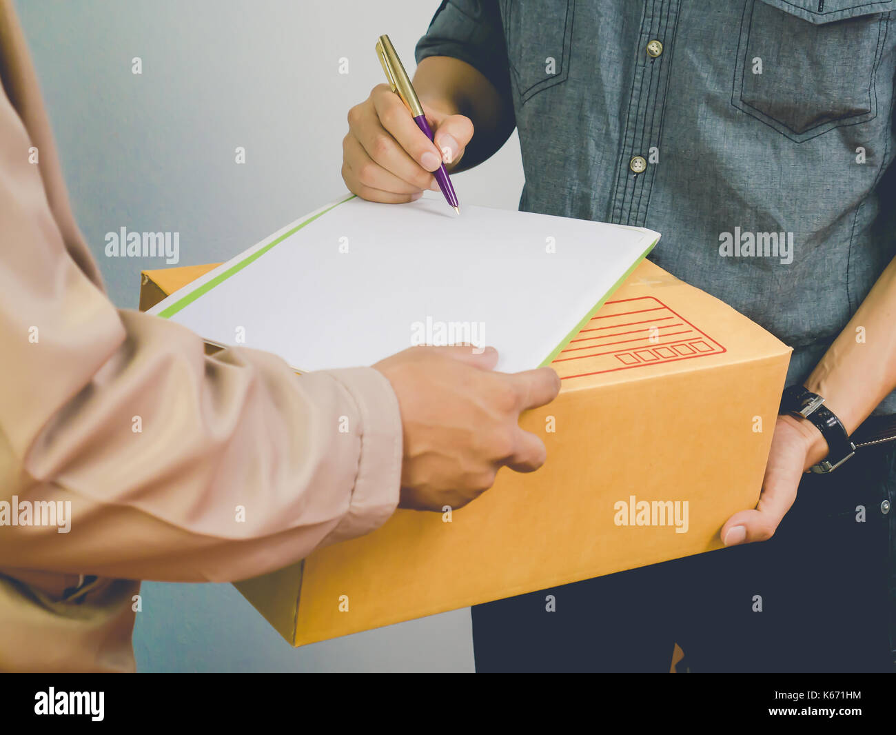 Man accepting a delivery of cardboard boxes from deliveryman Stock Photo