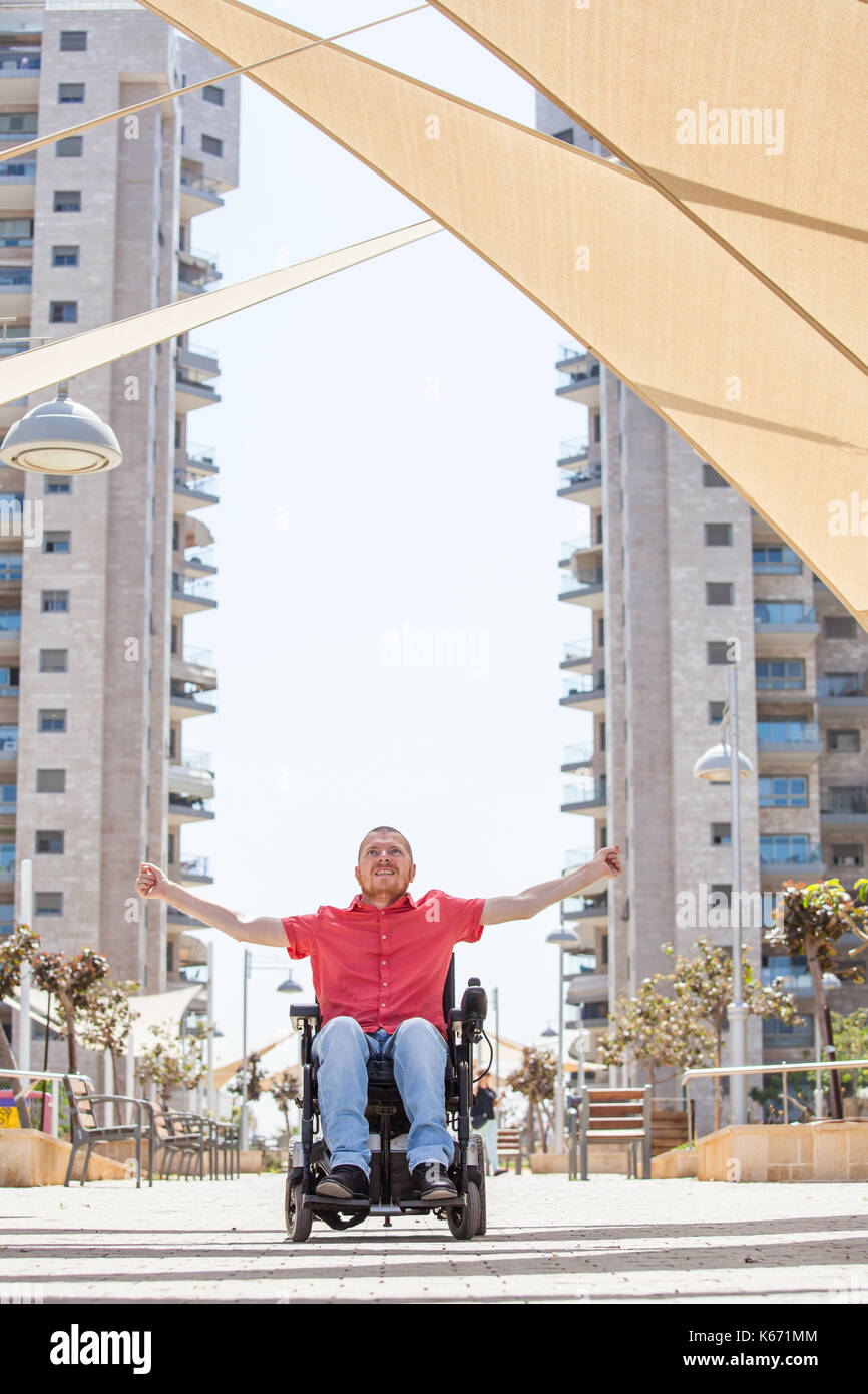Disabled man in a wheelchair enjoying fresh air outdoors Stock Photo