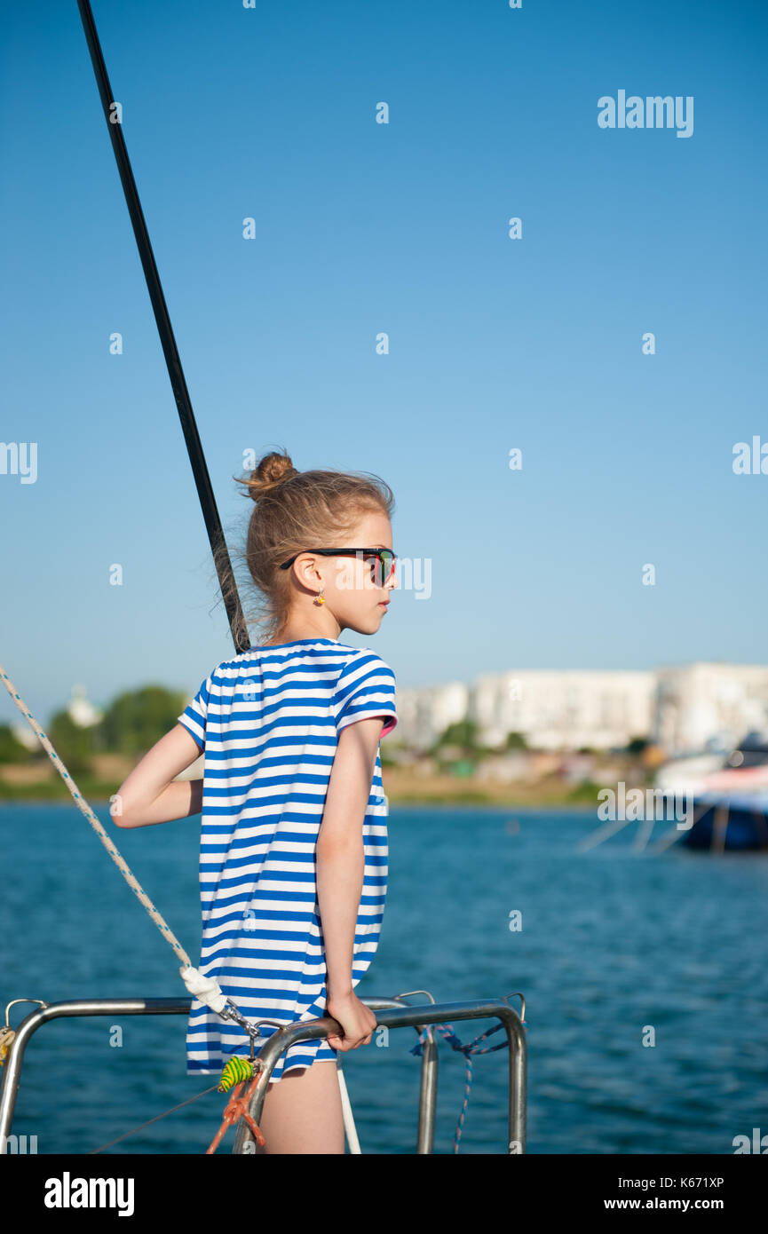 little girl in a straw hat in the harbour looking at the fish in the sea  Stock Photo - Alamy