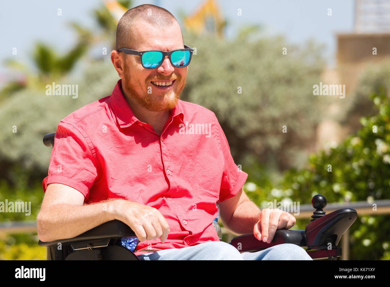 Disabled man in a wheelchair enjoying fresh air at the park Stock Photo ...