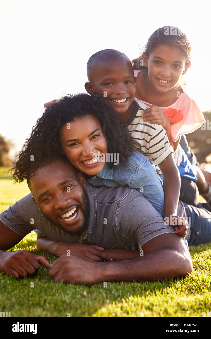 Happy black family lying in a pile on grass outdoors Stock Photo - Alamy