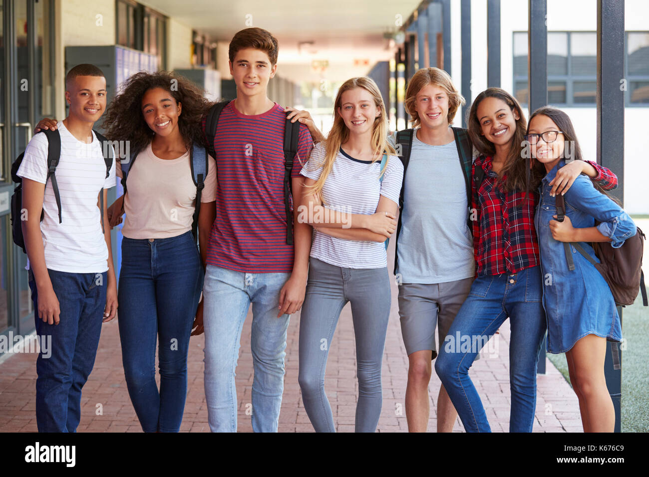 Teenage classmates standing in high school hallway Stock Photo