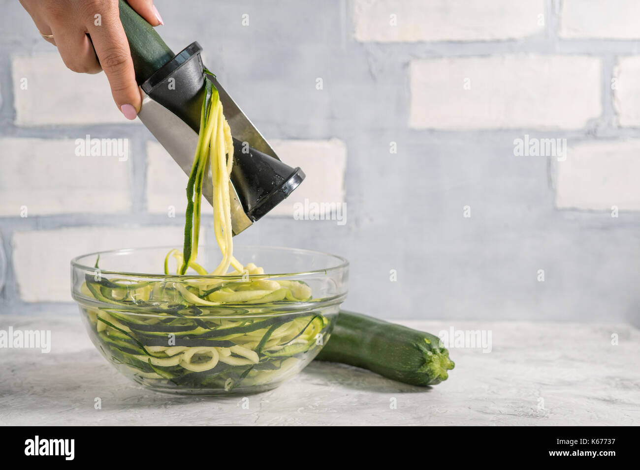 Making zucchini noodles with spiralizer. Diet low carb food Stock Photo