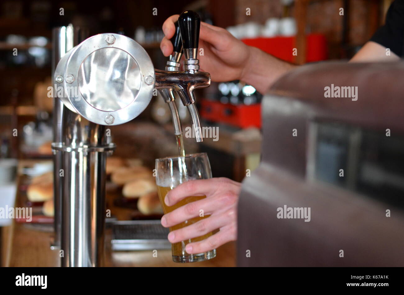 Man pulling a pint of beer in a bar Stock Photo