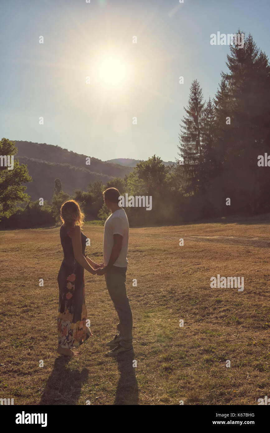 Couple standing in rural landscape holding hands Stock Photo - Alamy