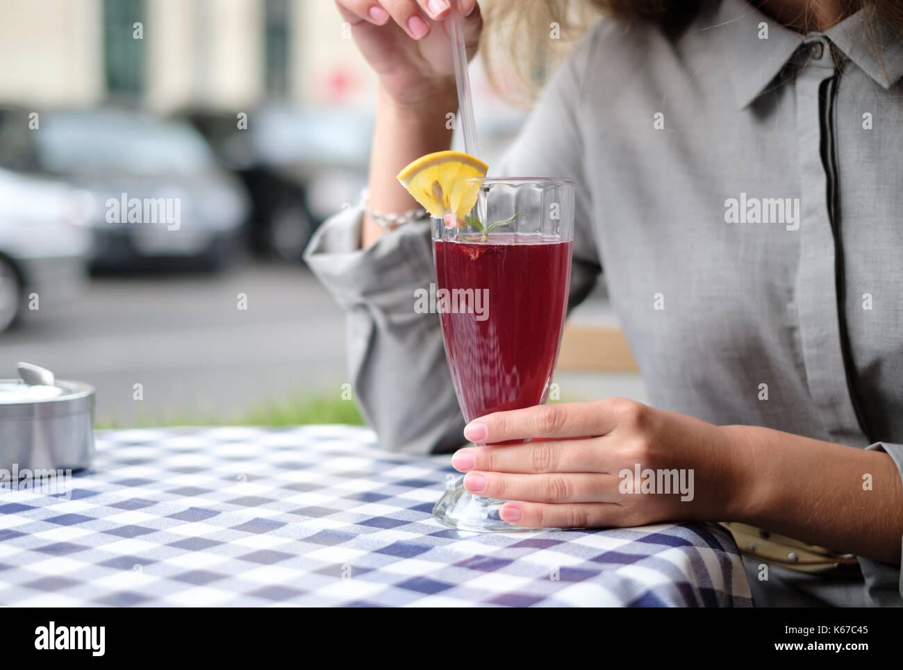 Woman in a cafe drinking a cranberry cocktail Stock Photo