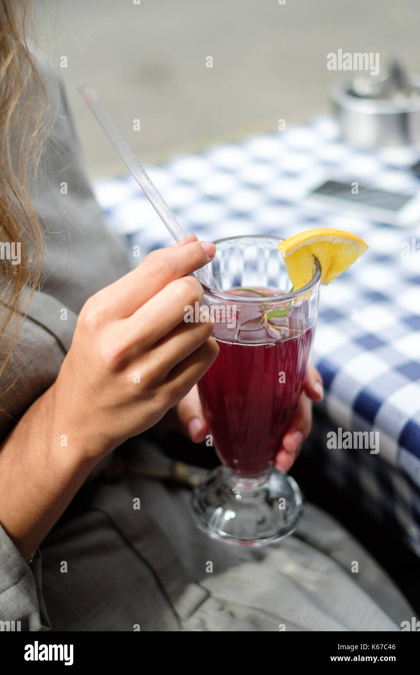 Woman in a cafe drinking a cranberry cocktail Stock Photo