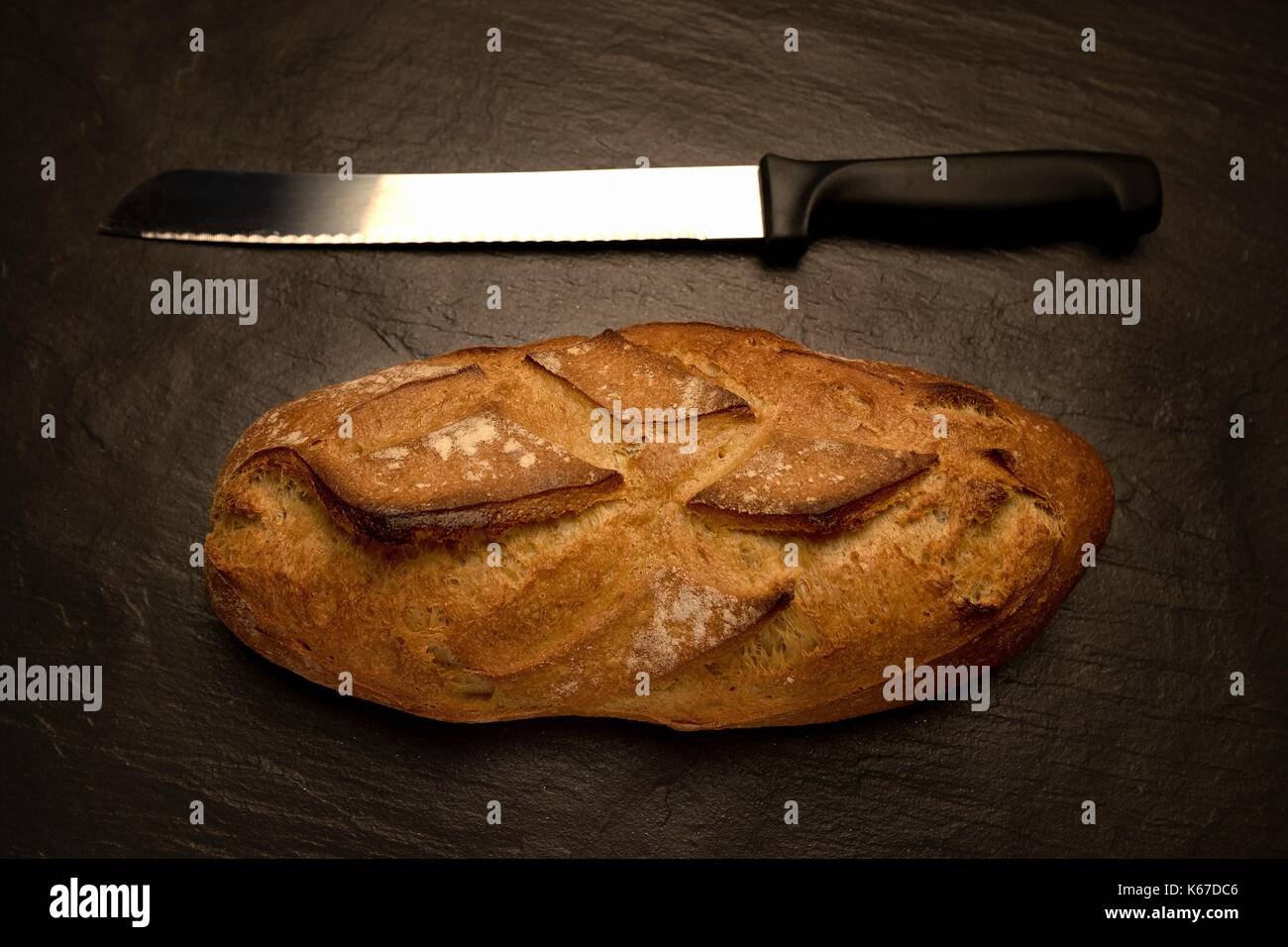Loaf of bread with a bread knife Stock Photo Alamy