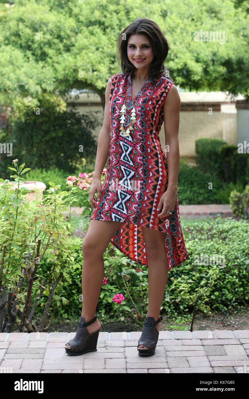 brunette woman wearing a patterned mini dress Stock Photo