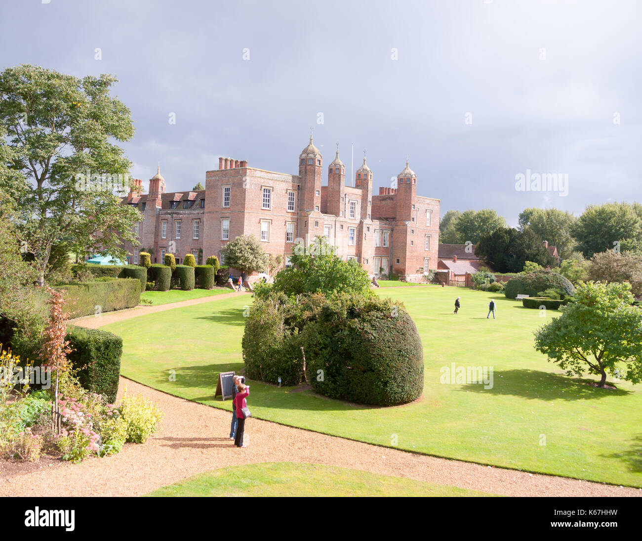 sunny overcast back garden view with people visiting long melford